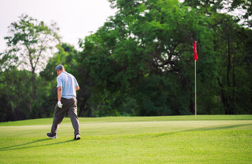 Obraz premium Senior Golfer Man Practicing on Golf Green During Summer Vacation for Active Lifestyle and Healthy Retirement