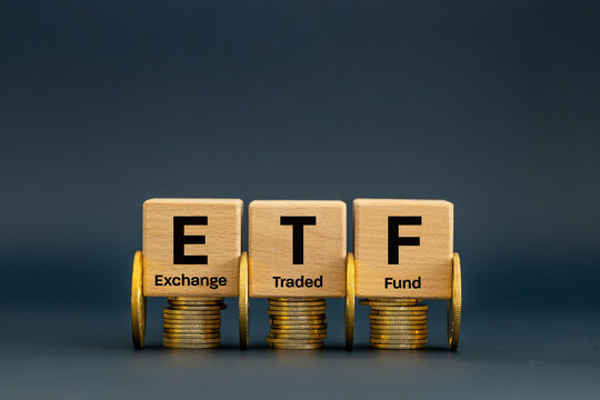 Symbol ETF, Exchange Traded Fund, Business and financial concept. Wooden cubes with an ETF icon on a navy blue background. A stock market index fund in the financial sector for business stocks. - Powered by Adobe
