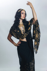 A young brunette woman in a black Indian sari on a white background, full-length photo, traditional Indian outfit