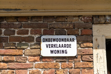 Dutch Warning Sign on Brick Wall Declaring House Uninhabitable