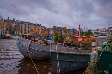 Obraz premium Boats filled with various items, plants, plant pots, pallets, and other supplies.