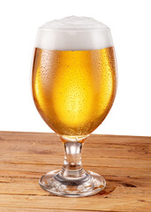 Glass of chilled light beer with beer foam and gas bubbles rising inside, isolated on white background. Clipping path.