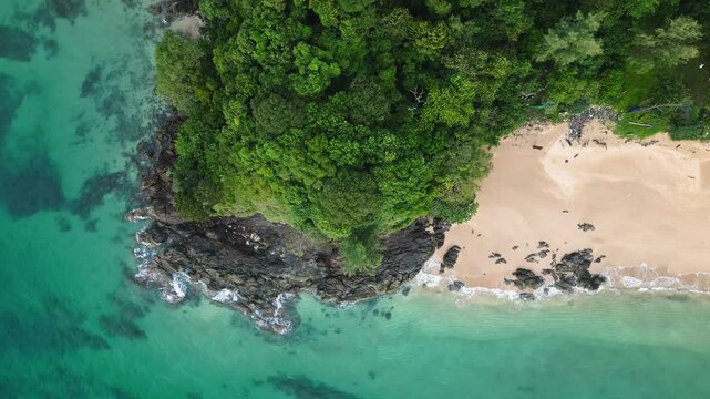 Aerial drone view of a tropical beach on Ko Lanta island, Thailand, with white sand, turquoise sea, rocky cliffs, palm trees, and lush jungle&mdash;an idyllic holiday destination for tourists.