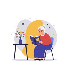 Elderly woman reading open book while sitting in chair with flowers  