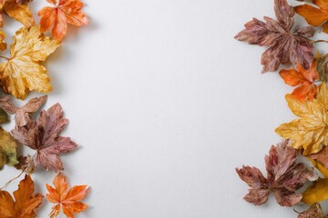 Autumn leaves frame a blank textured white surface