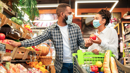 Grocery Shopping. African Family Couple In Masks Buying Vegetables Together Standing With Shop Cart...