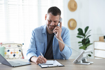 Travel agent working at wooden table in office