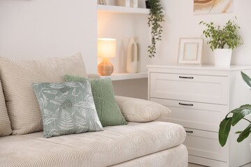Sofa with cushions and chest of drawers indoors