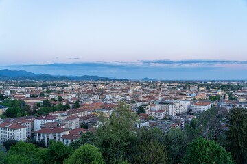 Fototapeta premium Bergamo cityscape at dusk with mountain backdrop.