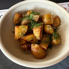 Deliciously roasted potato chunks, perfectly golden-brown and seasoned, generously garnished with fresh dill. A rustic and comforting side dish, ideal for a wholesome meal.