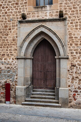 Gothic-style door with steps in a building in Plasencia, Cáceres province, Spain