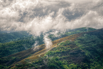 Morning fog rises to form low clouds over the mountains