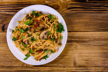 Pasta with mushrooms and tomato sauce in a plate. Top view