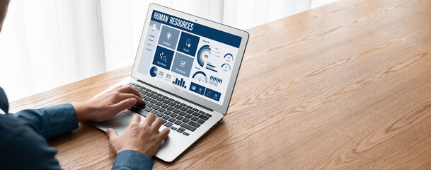 Human resources management software on computer screen helping human resources employee to manage...