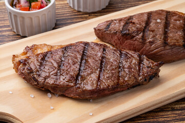 Grilled picanha beef over wooden board with vinaigrette