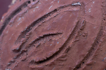 Intricate Textures Close-Up of a Deep Red Clay Surface with Carved Details