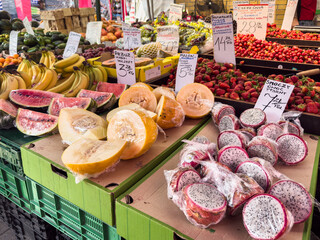 Owoce egzotyczne, bazar, handel, stragan. Żółty melon, melon miodowy, dragon fruit, smoczy owoc.