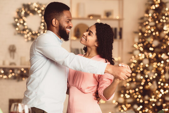 Fototapeta Couple In Love. Smiling young african american man and woman dancing at home. Happy black family of two enjoying time together, celebrating event, holiday, anniversary or St Valentine's day
