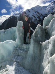 Woman standing on ice steps glacier with ice climbing gear