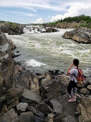 Woman hiker looking back at waterfall, Great Falls Virginia 