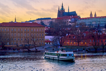 The passenger boat on Vltava river against Mala Strana district and St Vitus Cathedral, Prague,...