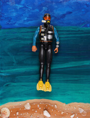 toy scuba diver on sea background