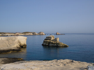 Iconic Sarakiniko beach on Milos, with white cliffs and blue water under a clear sky.