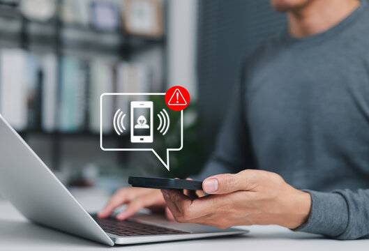 Phone scam alert notification concept. A man holding smartphone with scam warning notification, fraudulent calls, cybersecurity threats, fraud, scammer, and telecommunication security awareness.
