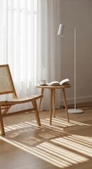 Sunlight streams into a room with a light wooden chair and table, a book and cup.