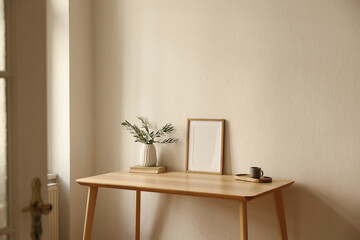 Vase with olive branches, old books. Cup of tea, coffee on table. Home office corner through open...