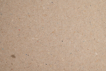 Recycled brown paper texture with fibers and specks
