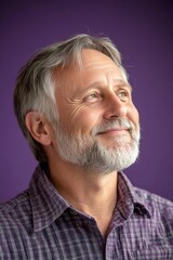 Obraz premium Concept art of style for aging men. Purple solid background. A middle-aged man looking happy and relaxed. Modish men's short caesar haircut - midlife white man with hair.