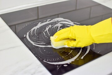 Woman cleaning modern hob. Housekeeping.