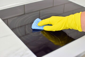 Woman cleaning modern hob. Housekeeping.