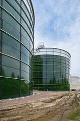 Neubau einer modernen Biogasanlage, Nahaufnahme von mehreren großen Stahlsilos - Hochformataufnahme.