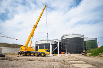 Aufstellen von großen Betonteilen mit einem Baukran für den Bau einer Industriehalle und Biogasanlage.