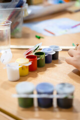 Children draw on the poster with pencils and paints