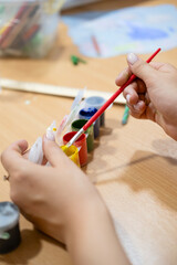 Children draw on the poster with pencils and paints