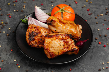 juicy golden grilled barbecue meat with spices on dark background