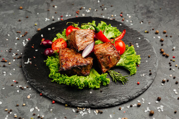 juicy golden grilled barbecue meat with spices on dark background
