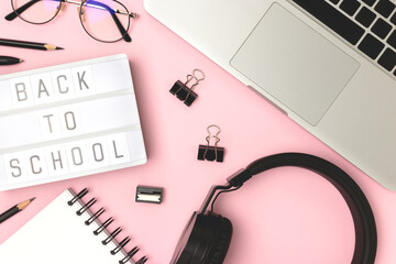 Back to school. Lightbox, headphones, laptop and stationery on a pink background. Workspace for online education.