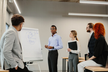 Businessman giving presentation to colleagues in modern office