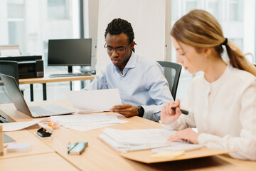 Business colleagues reviewing documents at office desk