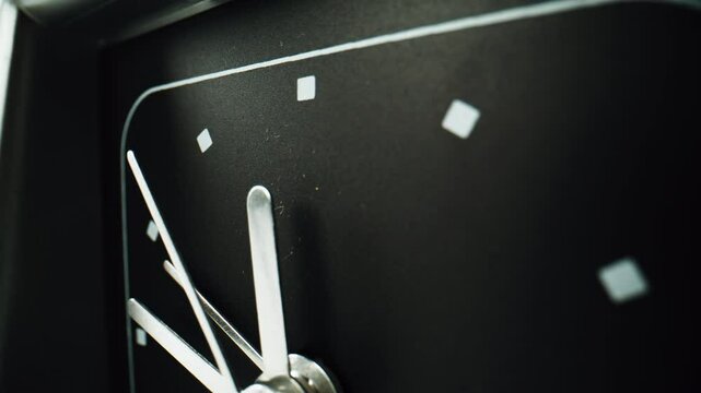 Closeup arrows ticking black clock background. Macro view metal hand running