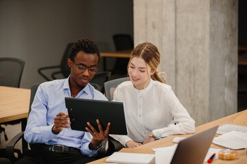 Fototapeta premium Business colleagues collaborating on project using tablet in office