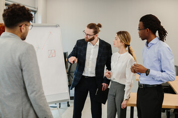 Business team analyzing data on whiteboard during office presentation