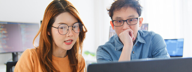 Asian male, female programming developer work together at home office, brainstorm discussion. Information technology, software engineer programmer coding job, man and woman coworker teamwork concept