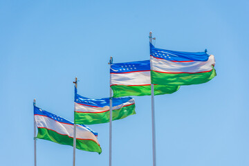 Waving Uzbekistan  flags on a blue sky background