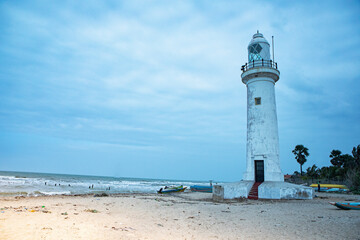 The lighthouse at Talaimannar standing on a sandy beach with blue skies.