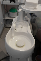 Close-up of a dental chair with integrated sink in a clinic setting